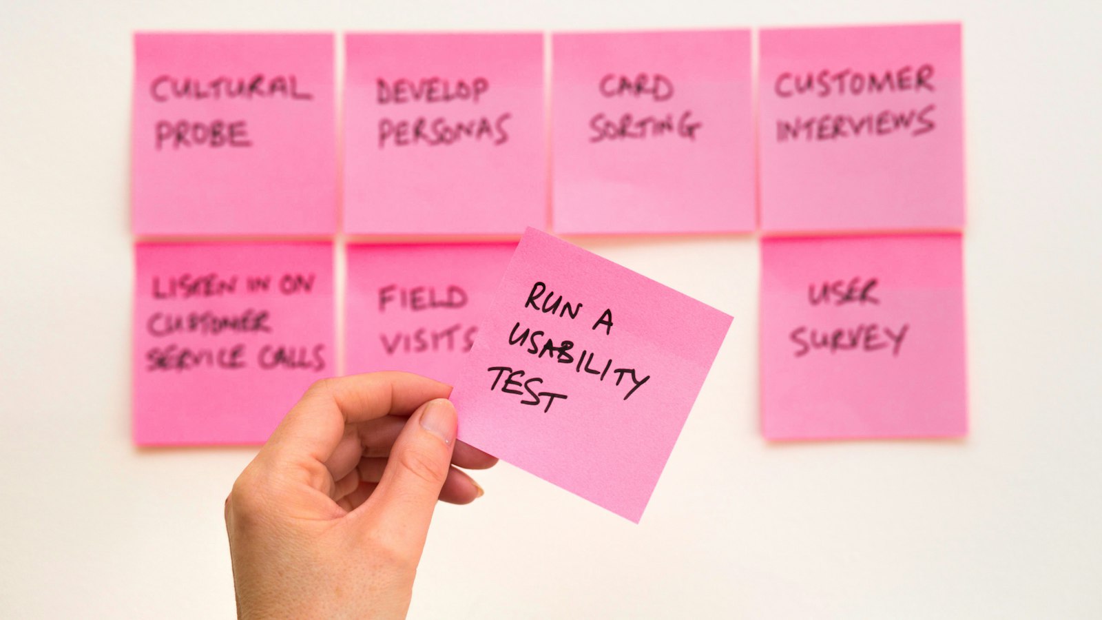 Person holding pink sticky note