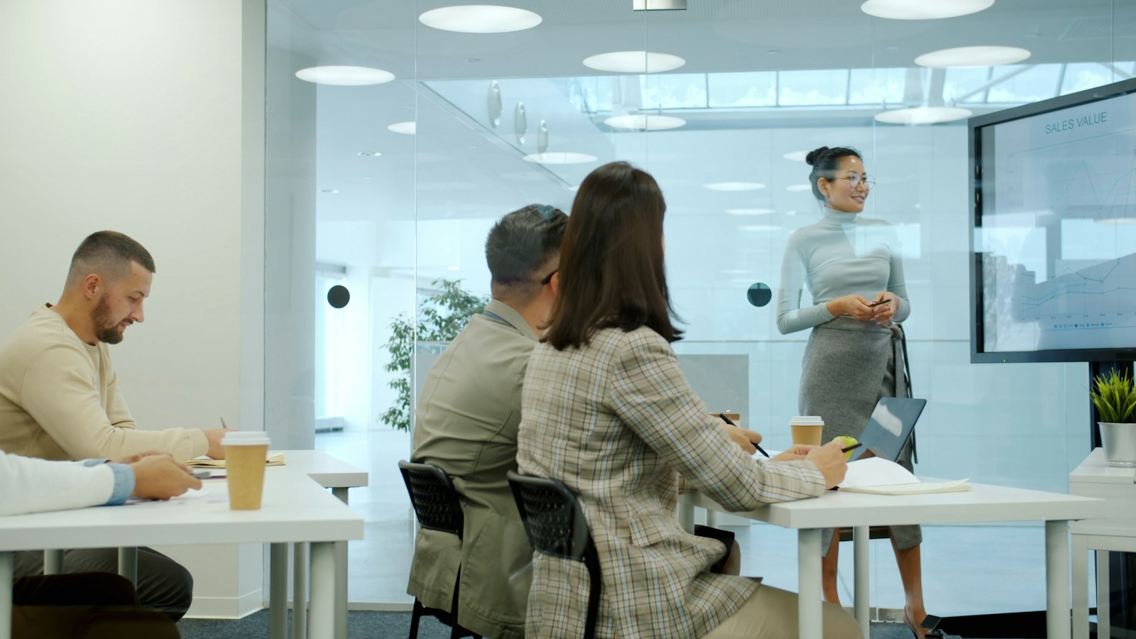 Woman presenting to colleagues in a modern office meeting